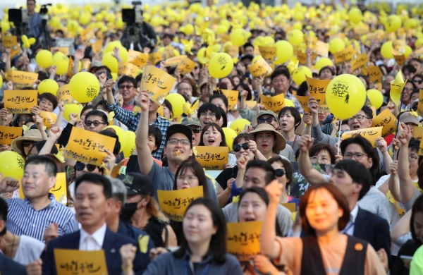 18일 오후 서울 광화문광장에서 열린 고 노무현 대통령 서거 10주기 시민문화제에서 참가자들이 '새로운 노무현'이 적힌 손팻말을 흔들고 있다.
