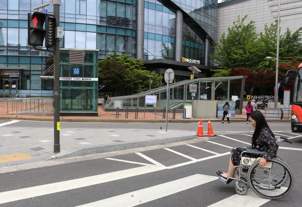기자가 휠체어를 타고 서울 서대문역 사거리 횡단보도를 건너는 중에 신호등이 빨간불로 바뀌었다. ⓒ이정실 여성신문 사진기자