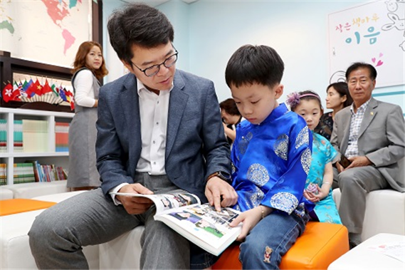 정원오 성동구청장과 중국 전통의상 치파오를 입은 어린이가 함께 그림책을 보고 있다. ⓒ성동구청