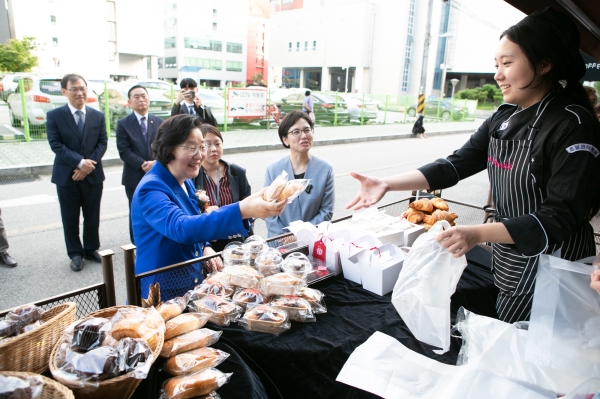 이정옥 여성부 장관이 학생 직접 만든 빵을 구매하고 있다.