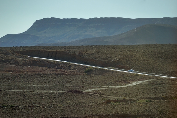 사하라 사막 입구 도시로 달려가는 길에 만난 작은 언덕. 쭉 뻗은 빛나는 길을 자동차가 빠르게 올라간다. (모로코 에르푸드 인근). 사진_조현주