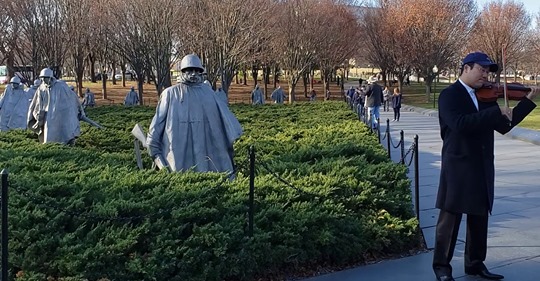 지난달 15일 미국 워싱턴 D.C. 한국전 참전 용사 기념비 앞에서 연주하는 원형준 음악감독 ⓒ린덴바움