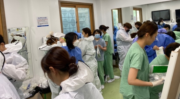 간호사들이 방호복을 입으러 착의실로 들어섰다. 여러 워드에서 근무하기 때문에 간호사들의 수가 많다. 2시간마다 방호복을 갈아입는다.