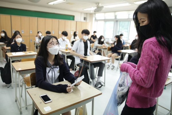 20일 오전 경기도 성남시 수내등학교에서 코로나19로 미뤄진 지 80일만에 등교한 고3학생은 담임 선생님이 나눠주는 마스크와 손소독제를 받고 있다. ⓒ홍수형 기자