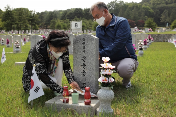 5일 오후 서울 동작구 국립서울현충원에서 한 부부는 내일 6일 현충일을 맞이하여 하루전 미리 찾아 참배하고 비석을 닦고 있다. ⓒ홍수형 기자