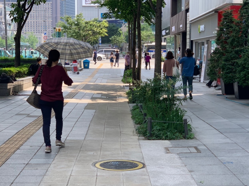 29일 오전 서울 종로구 광화문 거리에는 더위를 피하기 위해 한 여성이 양산을 들고 발걸음을 옮기고 있다. ⓒ홍수형 기자