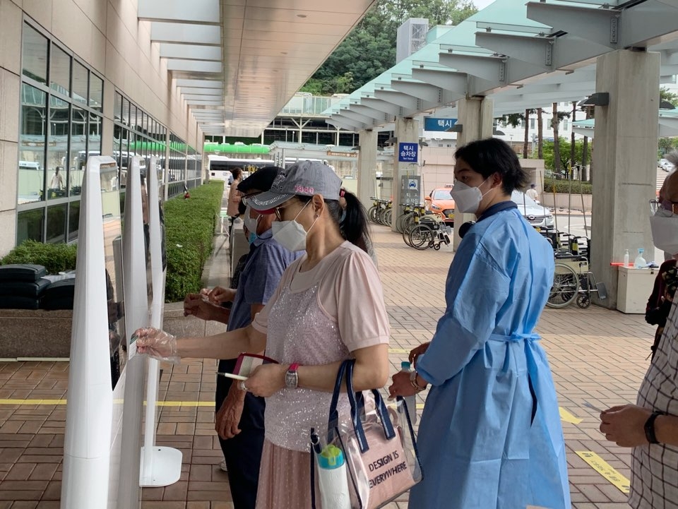 31일 오후 서초구 강남성모병원 입구에서는 코로나19 확산 예방을 위해 시민들은 전자 문진표를 작성하고 있다. ⓒ홍수형 기자