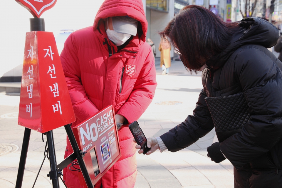 16일 오후 서울 중구 명동 거리에서 한 여성은 큐알코드로 자선냄비에 기부를 하고 있다. ⓒ홍수형 기자