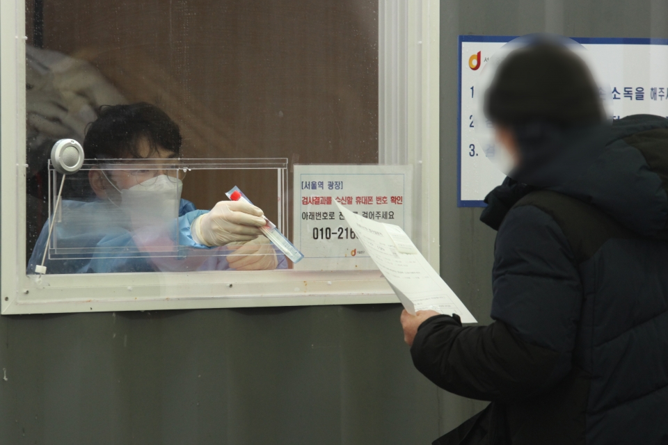 21일 오후 서울 중구 서울역 앞 선별진료소에서 한 시민은 코로나19 검사 받기 위해 검사 키트를 받고 있다. ⓒ홍수형