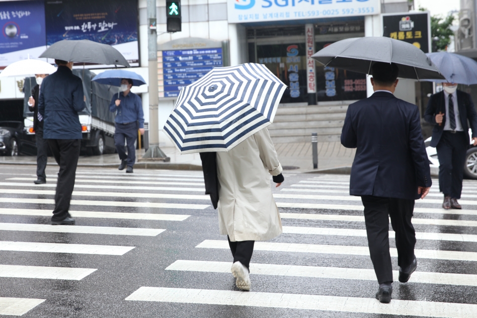4일 오후 서울 서초구 한 신호 거리에서 시민들을 비를 피하기 위해 발걸음을 옮기고 있다. ⓒ홍수형 기자