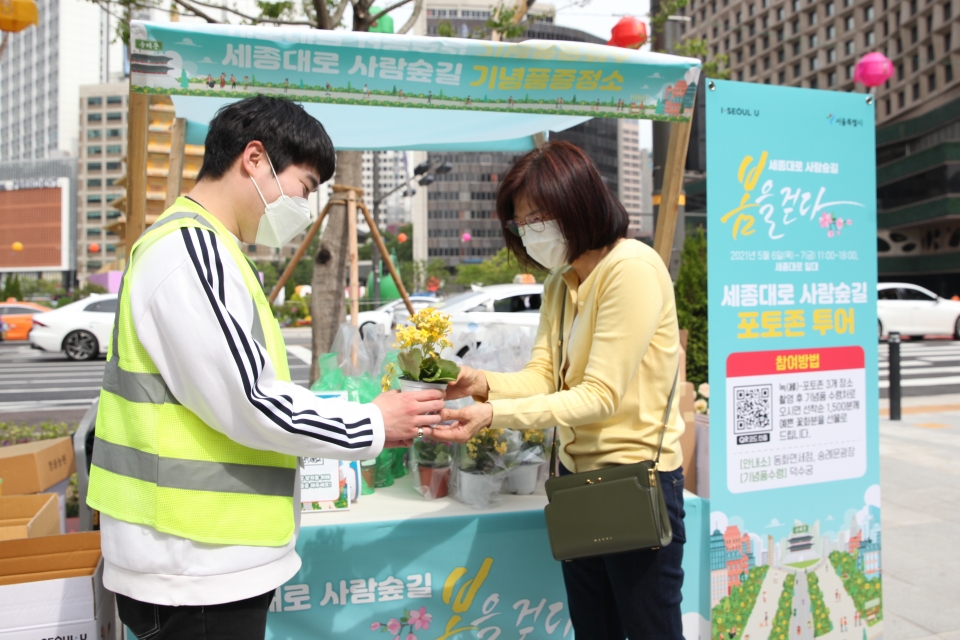 7일 서울 중구 세종대로 사람숲길 행사에서 한 시민은 포토 이벤트 참여하여 꽃을 받고 있다. ⓒ홍수형 기자