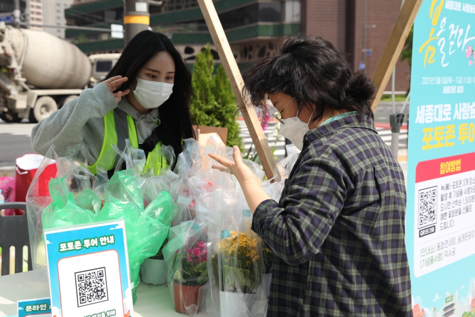 7일 서울 중구 세종대로 사람숲길 행사에서 한 시민은 포토 이벤트 참여하여 꽃을 고르고 있다. ⓒ홍수형 기자