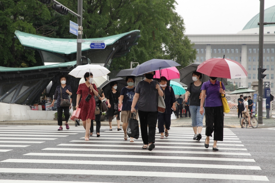 10일 오후 서울 여의도 국회의사당역 앞에서 시민들은 비를 피하기 위해 발걸음을 빠르게 옮기고 있다. ⓒ홍수형 기자