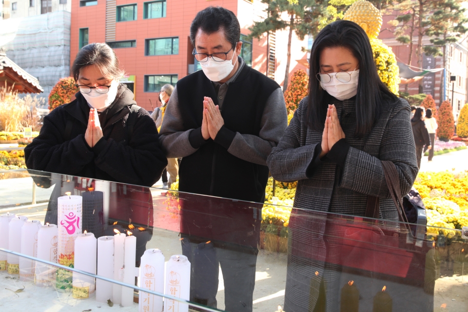 2022년도 대학수학능력시험을 이틀 앞둔 16일 서울 종로구 조계사에서 불신자들이 수험생을 응원하는 기원초 앞에서 기도하고 있다. ⓒ홍수형 기자