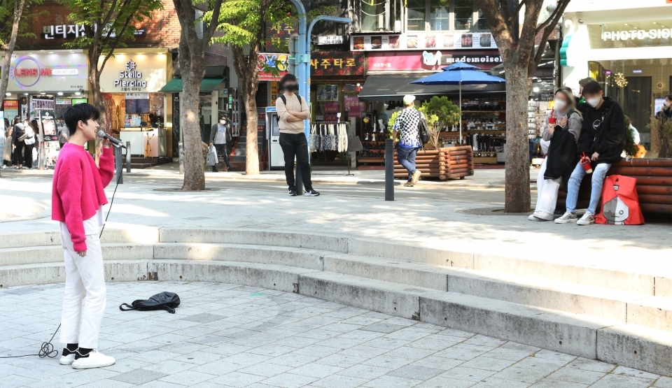 18일 서울 마포구 홍대걷고싶은거리 야외공연장에서 시민들이 버스킹 공연을 즐기고 있다. 코로나19 확산으로 야외 버스킹 공연 금지 조치가 지난 2020년 11월 이후 1년 4개월 만에 다시 재개했다. ⓒ홍수형 기자