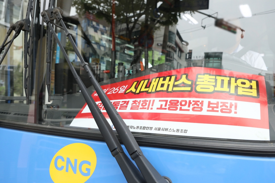 25일 서울 중구 인근 버스정류장에 도착한 시내버스 전면에 26일 예고된 버스노조의 총파업을 알리는 피켓이 놓여 있다. ⓒ홍수형 기자