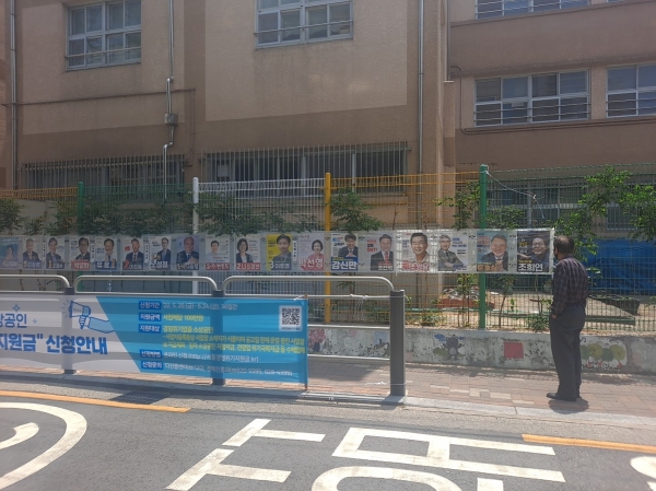 사전투표 이틀째를 맞은 28일 정오 서울 동작구 사당1동주민센터 앞 후보들의 포스터를 지나가던 행인이 보고 있다. ⓒ여성신문