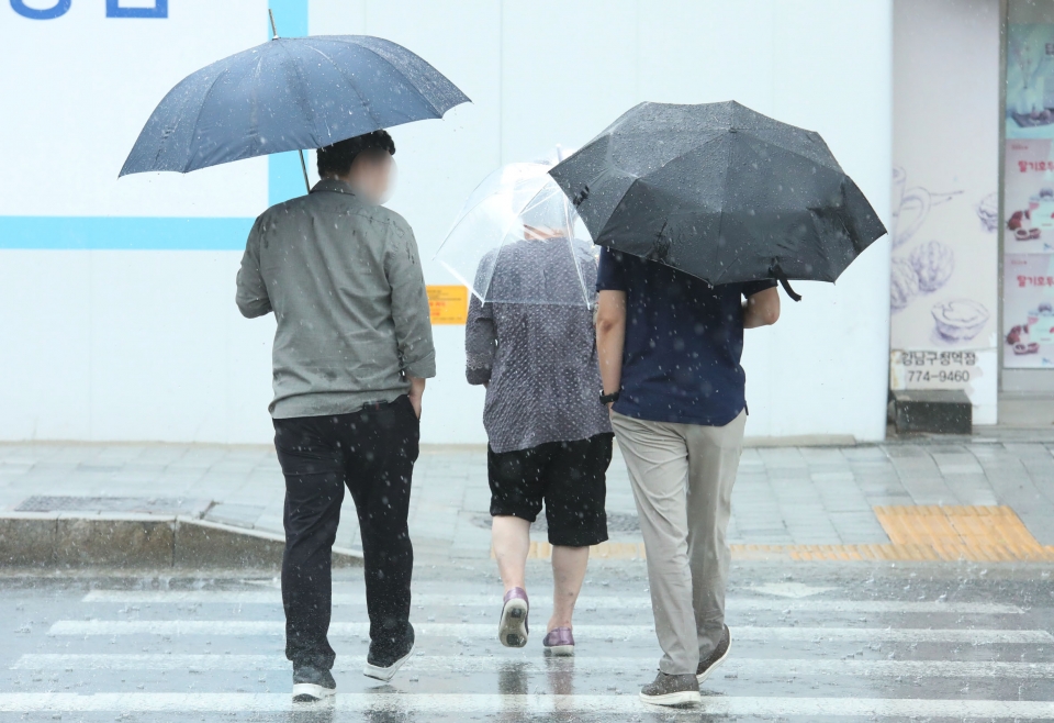 11일 서울 강남구에 위치한 한 신호거리에서 시민들이 비를 피하기 위해 발걸음을 옮기고 있다. ⓒ홍수형 기자
