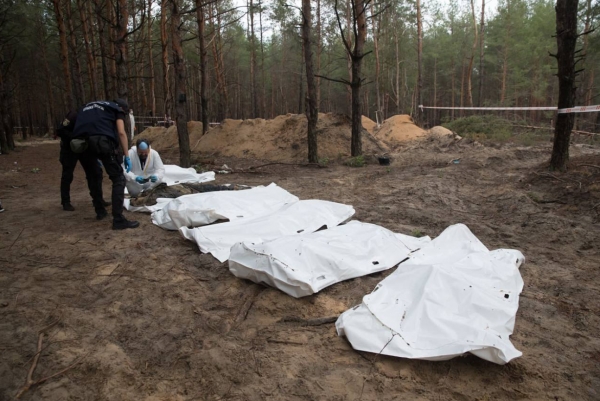 우크라이나 당국이 재탈환한 동부 이지움의 집단 매장지에서 시신을 수습하고 있다. ⓒ우크라이나 국방부 트위터