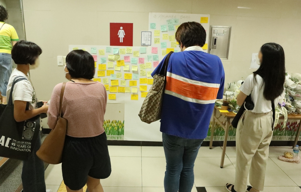 16일 서울 중구 신당역 여자화장실 앞에 마련된 추모공간에 피해자를 추모하기 위해 시민들이 작성한 포스트잇을 보고 있다. ⓒ홍수형 기자