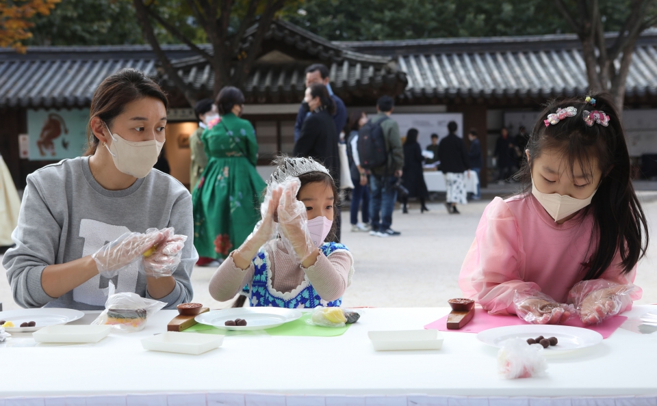27일 서울 종로구 운현궁에서 종로구가 개최한 '2022 궁중과 사대부가의 전통음식 축제'에서 시민들이 복주머니 향낭 만들기 체험을 하고 있다. ⓒ홍수형 기자