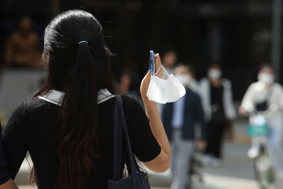 23일 서울 종로구에 위치한 한 거리에서 시민이 마스크를 들고 가고 있다. ⓒ홍수형 기자