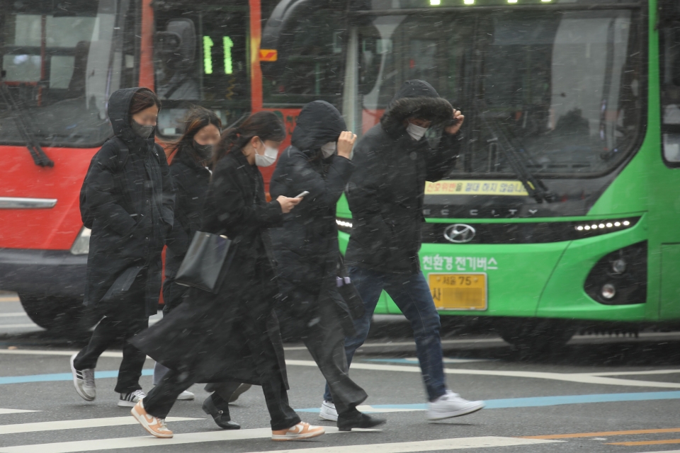 눈이 내리는 13일 오후 서울 종로구 광화문광장에서 시민들이 발걸음을 재촉하고 있다. ⓒ홍수형 기자