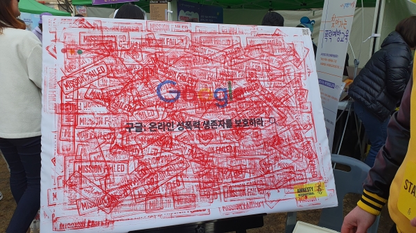 4일 진행된 한국여성대회에서 ‘국제앰네스티 한국지부’가 ‘구글: 온라인 성폭력 생존자를 보호하라’가 적힌 판넬에 ‘MISSION FAILED(미션 실패)’가 적힌 붉은 도장을 찍는 캠페인을 진행했다. ⓒ이수진 기자