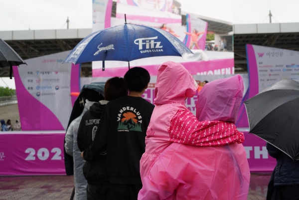 6일 오전 서울시 상암동 월드컵공원 평화의 광장에서 제23회 여성마라톤 대회가 열렸다. 분홍 우비를 맞춰입은 모녀가 무대를 바라보고 있다. ⓒ이수진 기자