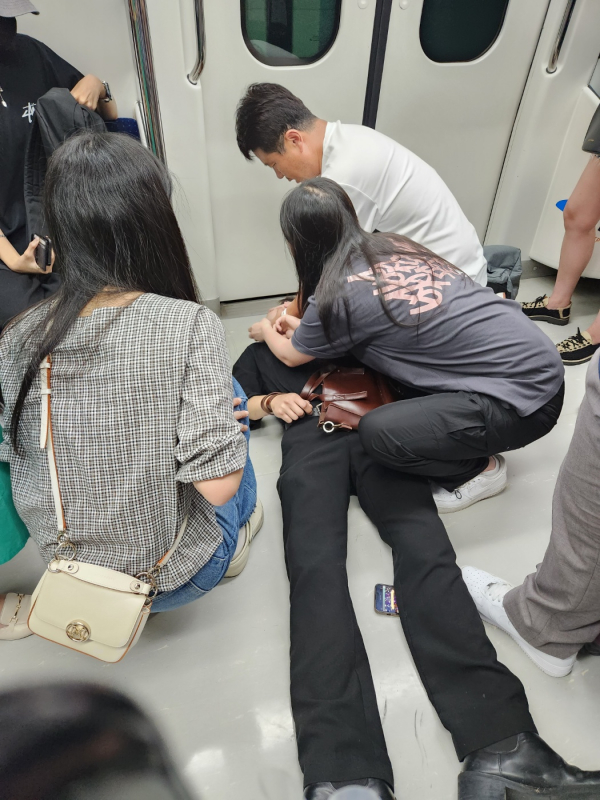 17일 오후 4시 40분쯤 공항철도안에서 쓰러진 남성을 승객들이 응급처치하고 있다. ⓒ여성신문