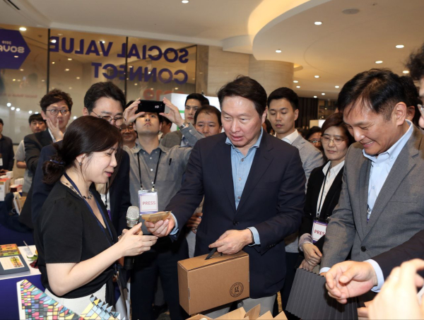 최태원(가운데) SK그룹 회장이 2019년 5월 서울 광진구 워커힐 호텔에서 열린 ‘SOVAC 2019’ 행사장에서 소셜벤처 제품을 구매하고 있다. ⓒSK그룹