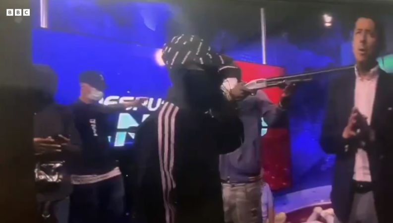 에콰도르의 과야킬 시의 공영 TV 채널 TC가 생방송 중 복면을 쓴 괴한들이 스튜디오에 침입해 진행자에게 총을 겨누며 위협하고 있다. ⓒBBC 화면 갈무리