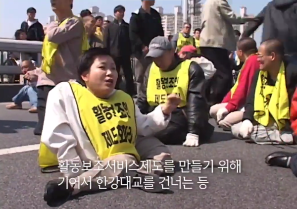 박김영희 대표는 2006년 활동보조서비스제도화 공동투쟁단 공동집행위원장으로 활동하며 장애 활동가들과 함께 기어서 한강대교를 건너는 투쟁에 앞장섰다.  ⓒ전국장애인차별철폐연대 영상 캡처