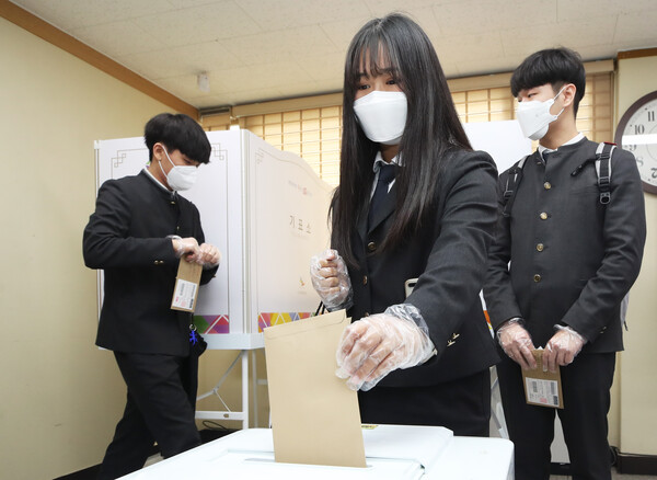 2020년 제21대 국회의원선거 사전투표  당시 경기도 수원시 팔달구 행궁동 행정복지센터에 설치된 사전투표소에서 선거연령 하향조정으로 처음으로 투표권을 행사하는 삼일공업고등학교 학생들이 투표하고 있다 ⓒ연합뉴스