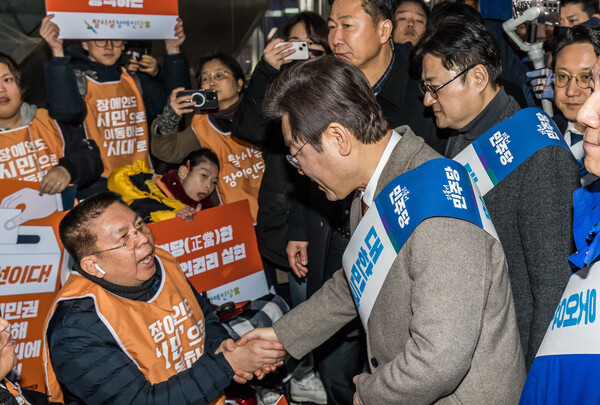 더불어민주당 이재명 대표가 8일 서울 용산구 용산역에서 탈시설장애인당 관계자들과 악수하며 이야기하고 있다 [공동취재] ⓒ연합뉴스