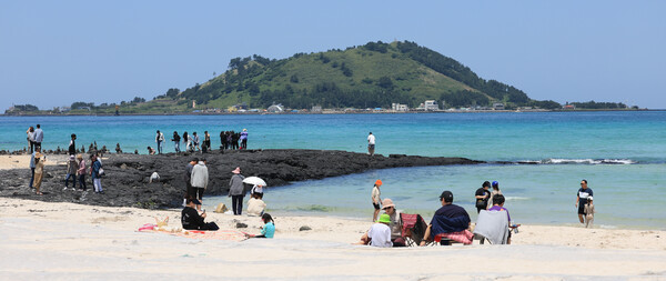지난 23일 오후 제주시 한림읍 협재해수욕장을 찾은 관광객이 여름 바다 정취를 만끽하고 있다. ⓒ연합뉴스