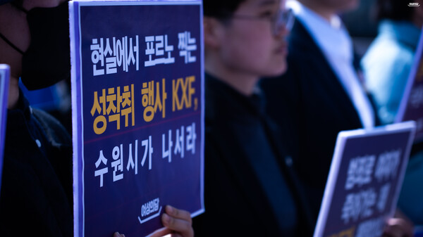 21일 수원역 앞에서 여성의당이 성인 페스티벌 규탄 기자회견을 개최했다. 한 참석자가 '현실에서 포르노 찍는 성착취 행사 KXF, 수원시가 나서라'는 문구가 적힌 피켓을 들고 있다. ⓒ여성의당