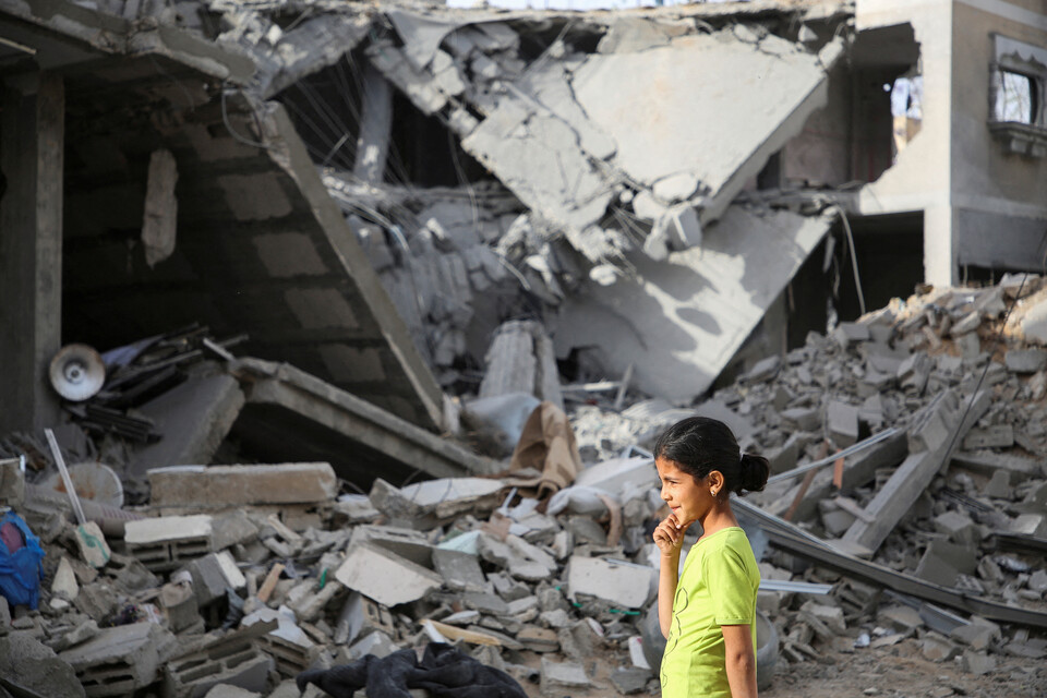 팔레스타인 소녀가 25일(현지시각) 이스라엘의 공격으로 파괴된 라파지구의 한 건물을 지나고 있다. ⓒ로이터 연합뉴스