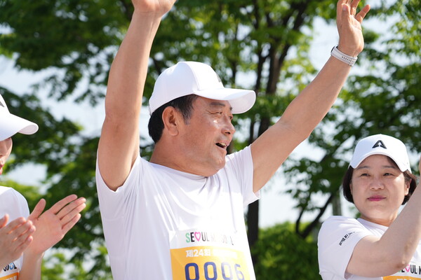 김영철 한성에프아이 대표이사(가운데)가 4일 오전 서울 마포구 상암동 월드컵공원 평화의광장에서 열린 제24회 여성마라톤 대회에 참석해 참가자들에게 손을 들어 인사하자 김효선 여성신문 대표(오른쪽)이 박수로 화답하고 있다. ⓒ여성신문·이동윤 사진작가 