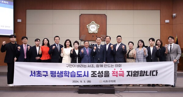 서울 서초구의회 의원 전원이 ‘서초구 평생학습도시 조성을 적극 지원합니다'라는 현수막을 들고 결의안 채택 기념촬영을 하고 있다. ⓒ서초구의회