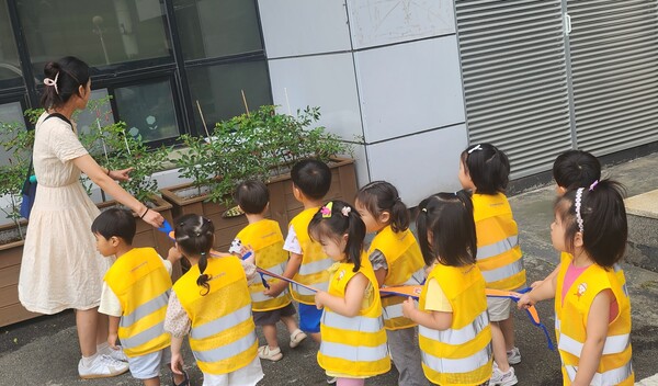 안전조끼를 착용한 어린이집 아이들이 안전띠를 잡고 이동하는 모습 ⓒ송파구