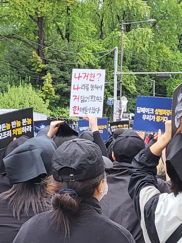 21일 '딥페이크 성착취물 엄벌 촉구' 시위에서 한 참가자가 '‘나라를 향해 거침없이 포효하는 한녀들이 왔다’'는 문구가 새겨진 피켓을 들고 있다. ⓒ이슬기 칼럼니스트