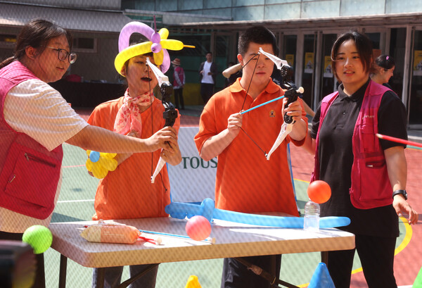  ‘2024 어깨동무 스페셜 운동회’ 부대 행사에 참가한 사람들이 양궁을 체험하고 있다. 