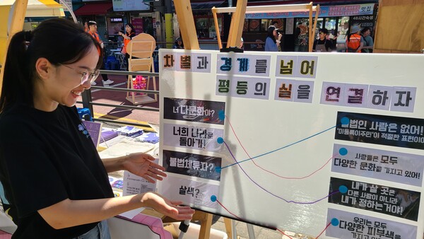 이주여성인권센터 부스 관계자가 인식 개선을 위한 간단한 문장 연결 게임을 선보이며 설명하고 있다. ⓒ성북구