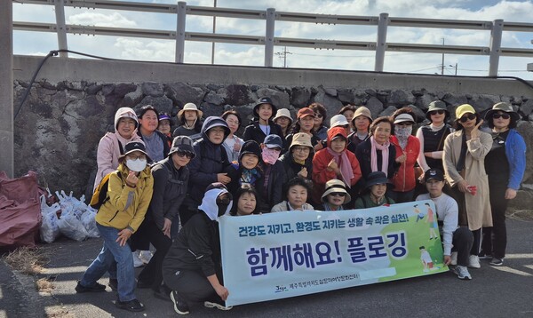제주 설문대여성문화센터 자원봉사자학교 수강생들이 지난 30일 제주올레길에서 플로깅 봉사활동을 진행하고 기념촬영을 하고 있다. 왼쪽 편에는 봉사자들이 수거한 쓰레기 봉지 더미가 쌓여있다. ⓒ제주도