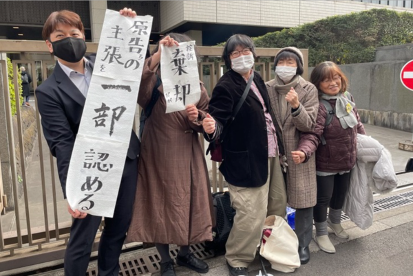 일본 ‘재가요양보호사 국가배상청구 소송’ 항소심 판결이 난 2월 2일, 도쿄고등법원 앞에서 원고들과 변호사가 “원고 등의 주장을 일부 인정한다."고 적은 종이 현수막을 펼치고 있다. ⓒ페민