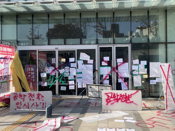 12일 남녀공학 전환에 반대하는 동덕여대 재학생들이 붉은색 라카 스프레이로 동덕여대 백주년기념관 입구에 ‘공학 전환 입시 사기’ 등의 글을 적은 모습.   ⓒ신미정 기자