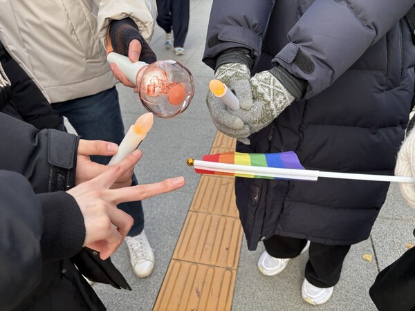 몽 씨와 친구들이 응원봉과 프라이드 플래그를 보여주고 있다ⓒ신다인 기자