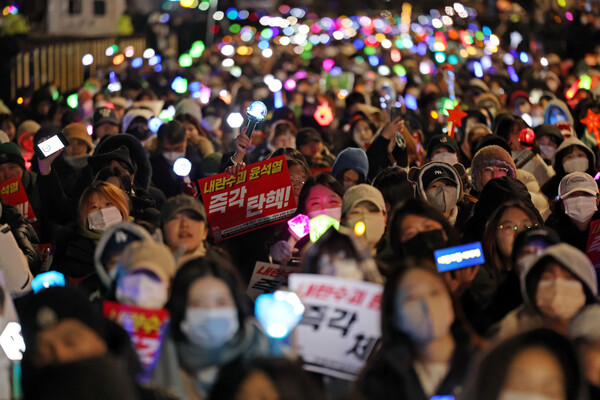 8일 오후 서울 여의도 국회 앞에서 열린 윤석열 탄핵 및 구속을 촉구하는 촛불문화제에서 참가자들이 관련 손팻말과 응원봉을 들고 있다.  ⓒ연합뉴스