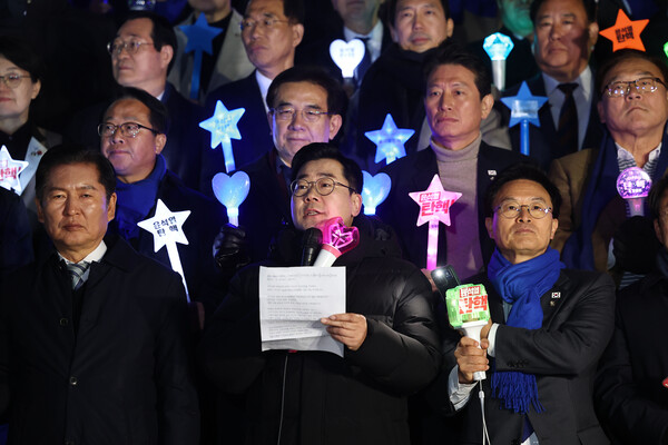 더불어민주당 박찬대 원내대표가 윤석열 대통령에 대한 2차 탄핵소추안 표결을 하루 앞둔 12월 13일 오후 국회 본관 앞에서 소녀시대 팬덤의 응원봉을 들고 결의문을 낭독하고 있다. ⓒ연합뉴스